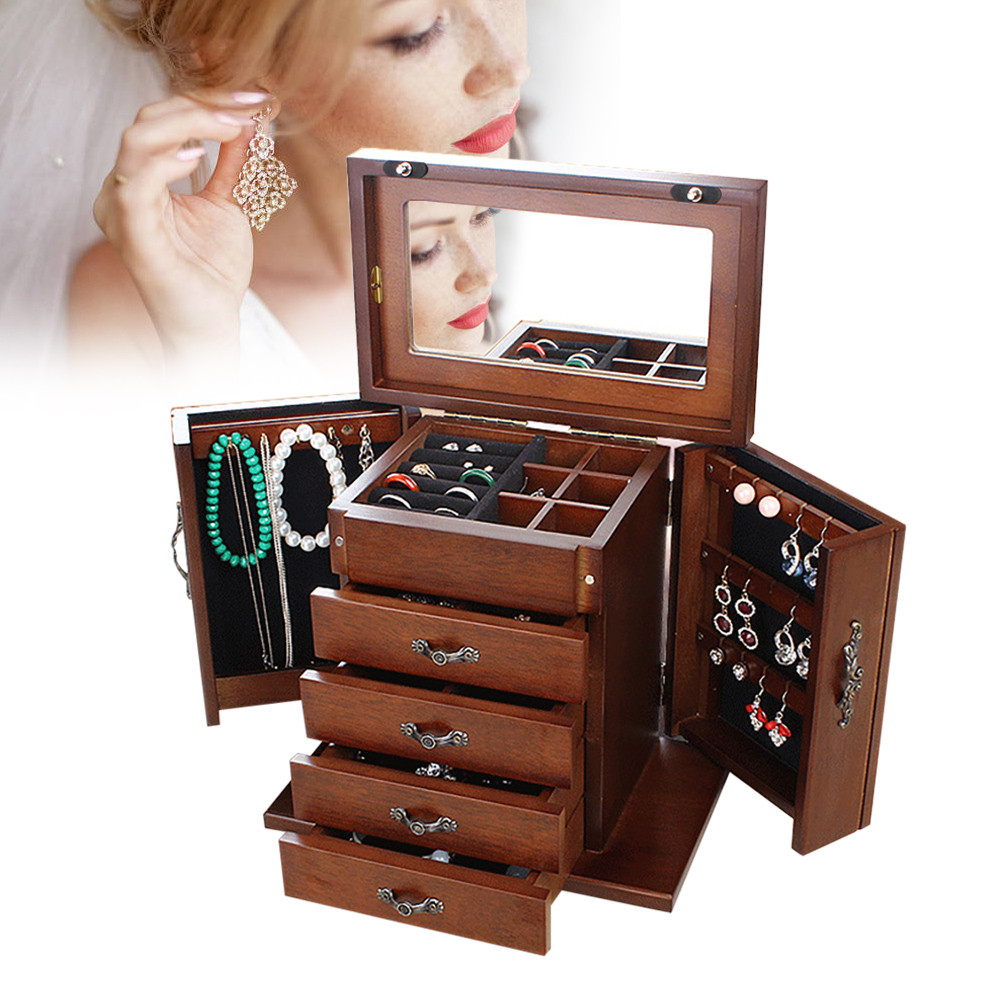 Woman holding earring near open jewelry cabinet